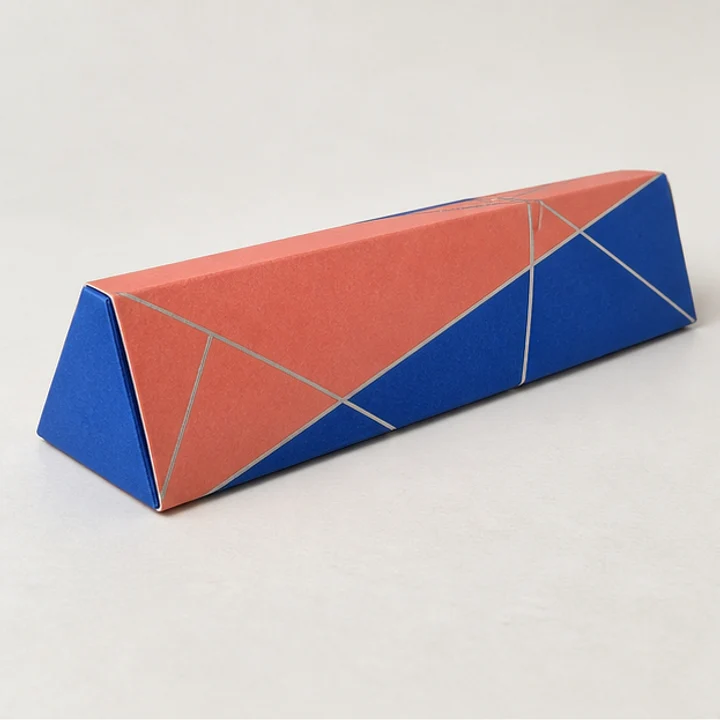 Closed triangular-prism folding carton with coral and blue printed paper